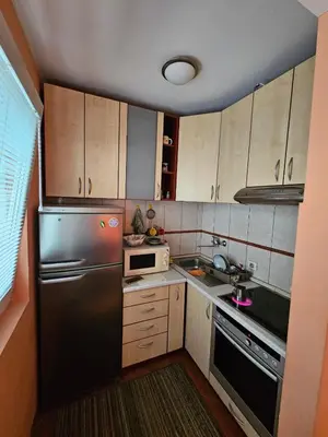 a small kitchen with a refrigerator and a sink at Apartman Orange Budva in Budva