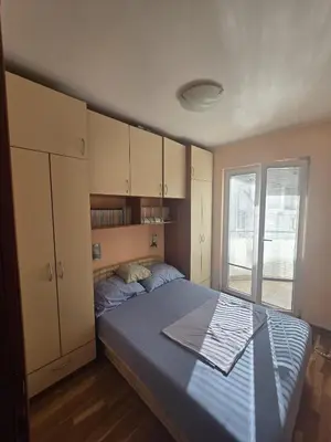 a bedroom with a bed and cabinets and a window at Apartman Orange Budva in Budva
