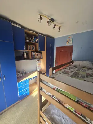 a bedroom with blue walls and a bed with a desk at Apartman Orange Budva in Budva