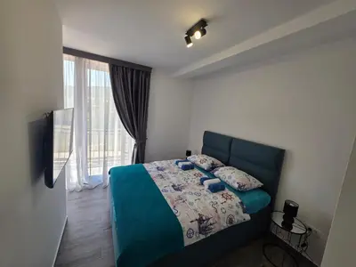 a bedroom with a blue bed and a window at Villa Azzurra in Radanovići