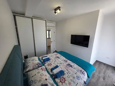 a bedroom with a bed and a flat screen tv at Villa Azzurra in Radanovići