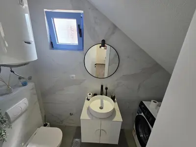 a small bathroom with a sink and a mirror at Villa Azzurra in Radanovići