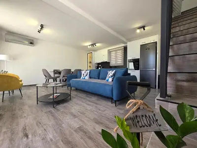 a living room with a blue couch and a table at Villa Azzurra in Radanovići