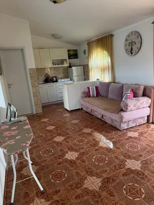 a living room with a couch and a kitchen at Apartments Sava in Dobra Voda