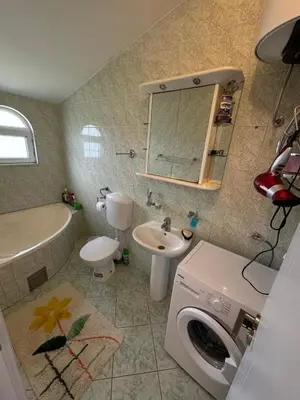a bathroom with a washing machine and a sink at Apartments Sava in Dobra Voda