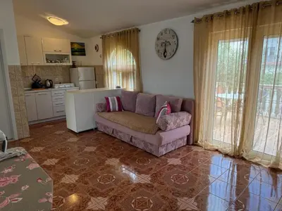a living room with a couch and a kitchen at Apartments Sava in Dobra Voda