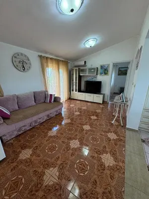 a living room with a couch and a clock on the wall at Apartments Sava in Dobra Voda
