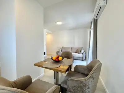 a living room with a table and chairs at Comfort Apartments Balkan in Budva
