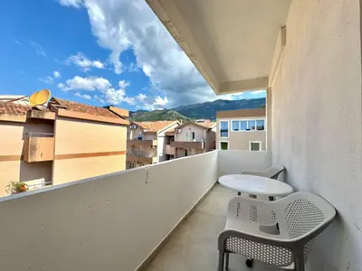 a balcony with a table and chairs and a view at Comfort Apartments Balkan in Budva