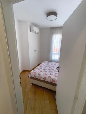 a small bedroom with a bed and a window at Sea view Chiron in Budva