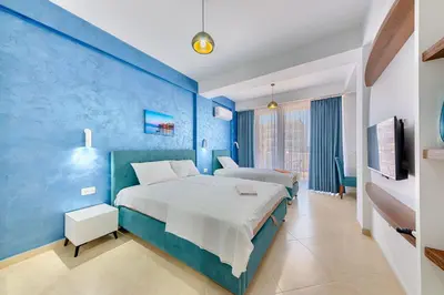a bedroom with two beds and a blue wall at Lotos - apart 207 L1 in Dobra Voda