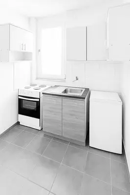 a white kitchen with a sink and a stove at Apartman Ulcinj in Ulcinj