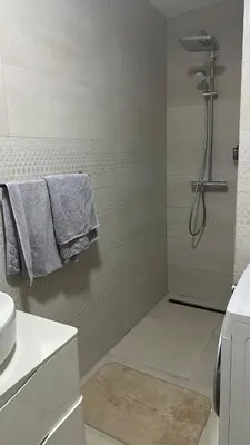 a bathroom with a shower with towels on a wall at Comfort in Bar