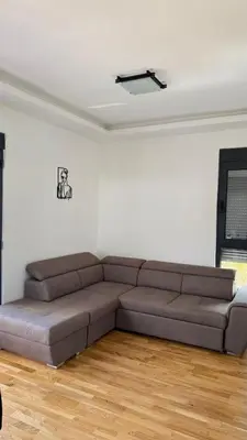 a living room with a brown couch in a white room at Comfort in Bar