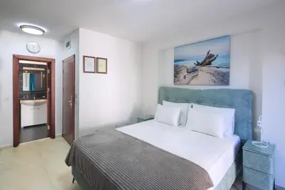 a bedroom with a large bed and a bathroom at Residence Tommy in Budva