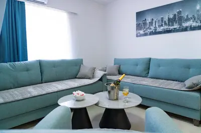 a living room with a couch and two tables at Residence Tommy in Budva