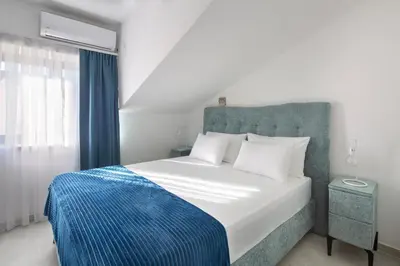 a bedroom with a bed with a blue and white blanket at Residence Tommy in Budva