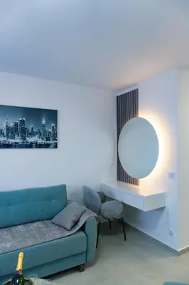 a living room with a blue couch and a mirror at Residence Tommy in Budva