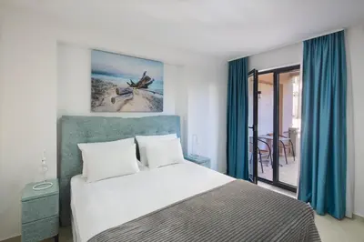 a bedroom with a large bed with blue curtains at Residence Tommy in Budva
