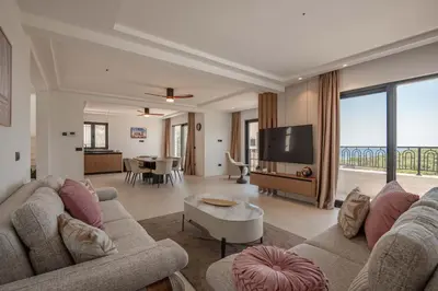a living room with a couch and a tv at Luxury Villa - New Building with pool and Fantastic Panoramic Sea View in Reževići