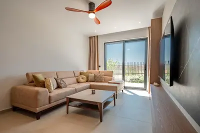 a living room with a couch and a ceiling fan at Luxury Villa - New Building with pool and Fantastic Panoramic Sea View in Reževići