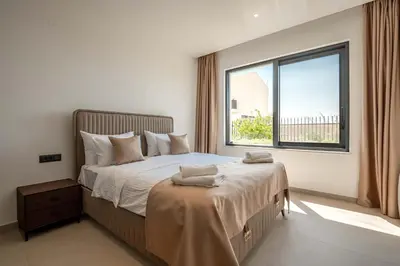a bedroom with a large bed with a window at Luxury Villa - New Building with pool and Fantastic Panoramic Sea View in Reževići