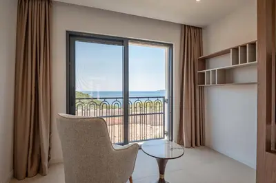 a room with a large window with a view of the ocean at Luxury Villa - New Building with pool and Fantastic Panoramic Sea View in Reževići