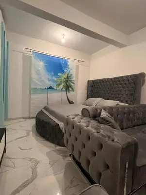 a bedroom with a bed and a couch and a window at Luxury Apartment With Sea View in Ulcinj