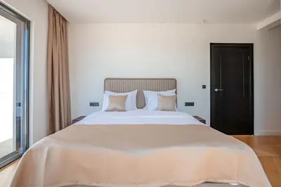 a bedroom with a large bed with a large window at Luxury Villa - New Building with pool and Fantastic Side Sea View in Budva