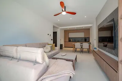 a living room with a couch and a ceiling fan at Luxury Villa - New Building with pool and Fantastic Side Sea View in Budva