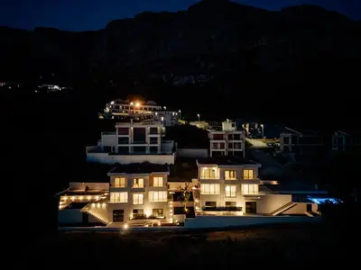 a group of buildings lit up at night at Luxury Villa - New Building with pool and Fantastic Side Sea View in Budva
