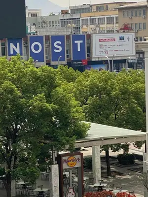 a gas station with trees and signs in a city at Heart of the city big 1BR on Independence square in Podgorica