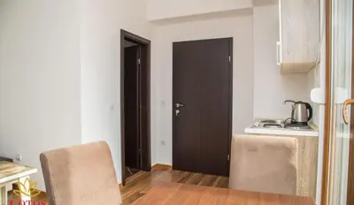 a kitchen with a table and two chairs and a door at Lotos - stan 421 L2 in Dobra Voda