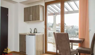 a kitchen with a desk and a table and a window at Lotos - stan 421 L2 in Dobra Voda