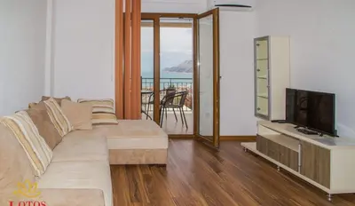 a living room with a couch and a television at Lotos - stan 211 L2 in Dobra Voda