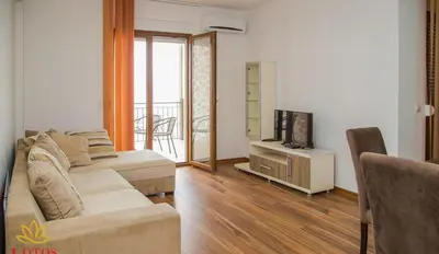 a living room with a couch and a television at Lotos - stan 211 L2 in Dobra Voda