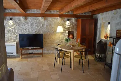 a living room with a table and a television at Unique stone apartment Villa M in Budva