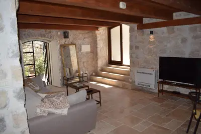 a living room with a couch and a flat screen tv at Unique stone apartment Villa M in Budva