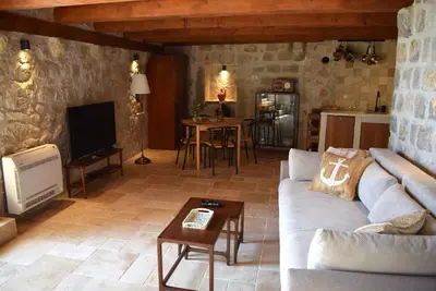 a living room with a couch and a table at Unique stone apartment Villa M in Budva