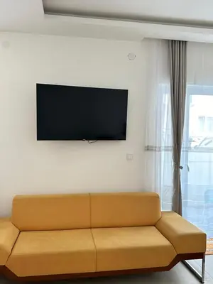 a living room with a couch and a flat screen tv at Garsonjera u centru Budve in Budva