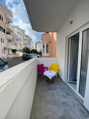 two chairs and a table on the balcony of a building at Garsonjera u centru Budve in Budva