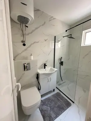 a bathroom with a shower and a toilet and a sink at Garsonjera u centru Budve in Budva