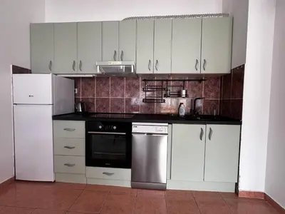 a kitchen with white cabinets and stainless steel appliances at Apartment Zevs 5 in Budva