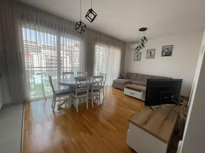 a living room with a table and a couch at Apartman Zlatni dan - zgrada Idea - Bečići in Becici