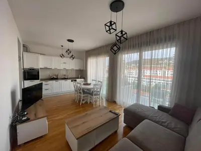 a living room with a couch and a table at Apartman Zlatni dan - zgrada Idea - Bečići in Becici