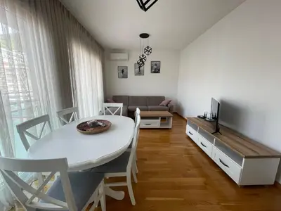 a living room with a white table and a couch at Apartman Zlatni dan - zgrada Idea - Bečići in Becici