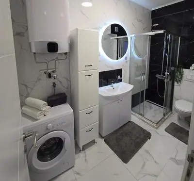 a bathroom with a washing machine and a sink at Apartment Olive Nest in Budva