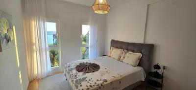 a bedroom with a bed and two windows at Apartment Olive Nest in Budva