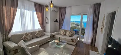 a living room with a couch and a large window at Apartment Olive Nest in Budva