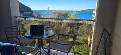 a balcony with a table with a laptop on it at Apartment Olive Nest in Budva